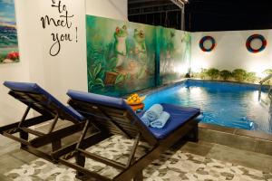 two chairs sitting next to a swimming pool at Entire Beach House in Tân Thành (1)