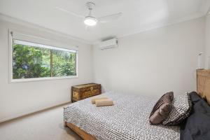 une chambre avec un lit et une fenêtre dans l'établissement Beach Cottage, à Woolgoolga