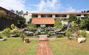 un jardín con una cascada frente a un edificio en Grand Beach, en Wadduwa