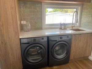 a kitchen with a washing machine and a sink at Elegant 3br Haven with Character & Charm in Yarram +18 photos
