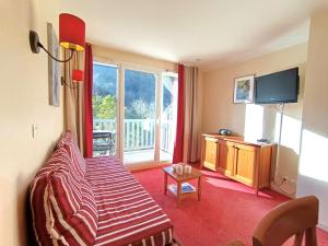 uma sala de estar com uma cama e uma televisão em T2 à Saint-Lary-Soulan avec Piscine et Parking pour 4 pers. - FR-1-457-358 em Saint-Lary-Soulan