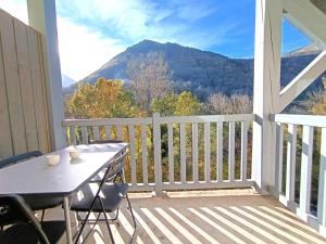 uma varanda com uma mesa e vista para uma montanha em T2 à Saint-Lary-Soulan avec Piscine et Parking pour 4 pers. - FR-1-457-358 em Saint-Lary-Soulan