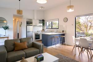 a living room with a couch and a kitchen at Gumleaf in Coles Bay