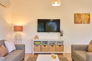 a living room with two couches and a flat screen tv at Gumleaf in Coles Bay +21 photos
