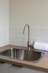 a stainless steel kitchen sink with a towel on it at Apartment Two - Apartments on Gavan in Bright +70 photos