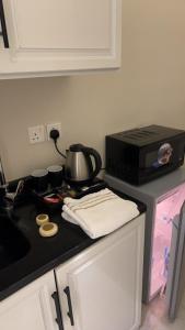 a kitchen with a stove with a tea pot and a microwave at Deluxe Boho - Self Check-in in Riyadh +12 photos
