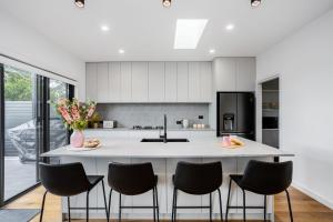 a kitchen with a large island with black chairs at You Yangs Vista in Portarlington