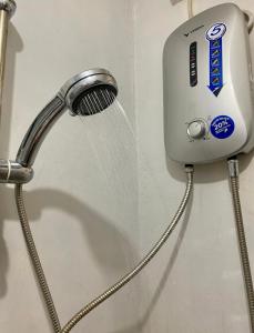 a shower head with water coming out of it at Affordable Staycation Home for 2-3 People! in Dauin