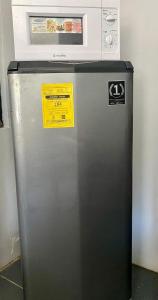 a refrigerator with a microwave on top of it at Affordable Staycation Home for 2-3 People! in Dauin