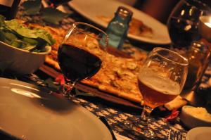 two glasses of wine on a table with a pizza at La Casona De Odile in El Bolsón