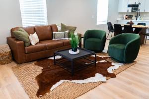 a living room with a brown couch and two green chairs at Family Style Home in South Knoxville in Knoxville