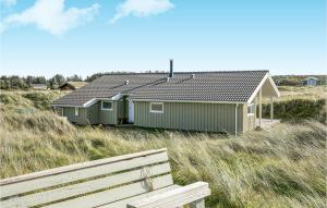 two green houses on a beach with a bench at Holiday Home Mathildevej Løkken Xii in Grønhøj