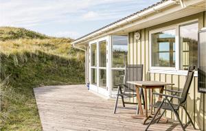 a wooden porch with chairs and a table on a house at Holiday Home Mathildevej Løkken Xii in Grønhøj +20 photos