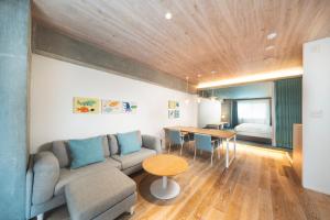 a living room with a couch and a table at BEB5 Okinawa Seragaki by Hoshino Resorts in Onna