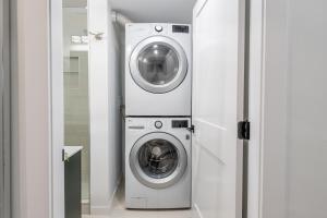 a washing machine and a washer and dryer in a room at Vancouver Central Green Studio in Vancouver