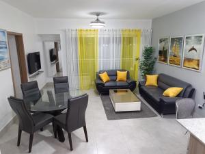 Una sala de estar con un sofá y una mesa de cristal. en Boca del Mar III, apartamento 706A, en Boca Chica