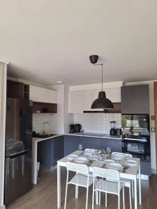 a kitchen with a white table and white chairs at Reñaca I Nuevo I Luminoso I Circuito Trekking in Viña del Mar