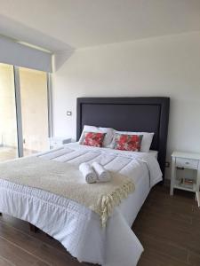 a bedroom with a large bed with two towels on it at Reñaca I Nuevo I Luminoso I Circuito Trekking in Viña del Mar