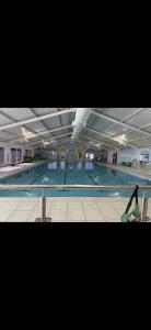 una persona che cammina attraverso una piscina in un edificio di Family Beach Getaway, Pools, Mountains and more a Prestatyn