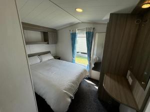 una piccola camera da letto con un letto e una finestra di Family Beach Getaway, Pools, Mountains and more a Prestatyn Altre 34 foto
