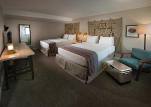 una camera d'albergo con due letti e una sedia di Basecamp Boulder a Boulder