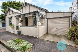 a white house with a garage in front of it at 'Urban Chic on Grey' - 3 Bedroom Retreat in Wickham in Wickham