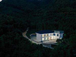 una casa nel mezzo di una foresta di notte di Tonglu HECHU Laf a Shanyinling