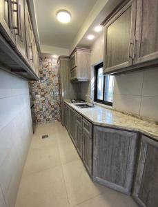 una cucina vuota con armadi in legno e lavandino di Qaimariya Farmhouse Amman - Day Use - Lodging - Events ad Amman