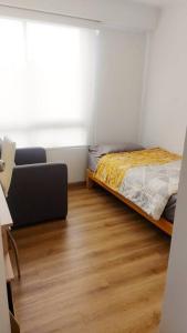 a bedroom with a bed and a chair and a window at Lovely & quiet place, park view & private parking in Lima