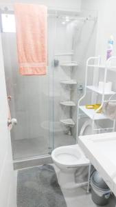 a white bathroom with a shower and a toilet at Lovely & quiet place, park view & private parking in Lima