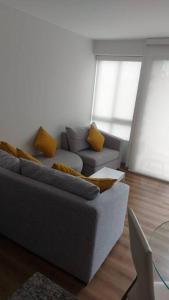 a living room with a gray couch and yellow pillows at Lovely & quiet place, park view & private parking in Lima +32 photos