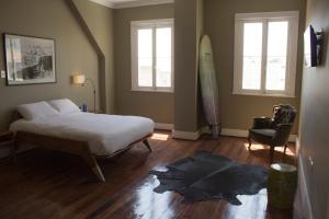 a bedroom with a bed and a surfboard on the floor at El Navegante B&B in Valparaíso