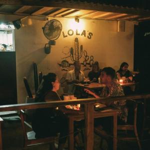 a group of people sitting at a table in a restaurant at 2 storey wooden house in the heart of Uluwatu in Uluwatu