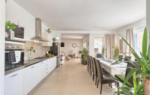 une cuisine avec des placards blancs et un grand comptoir dans l'établissement Amazing Home In Naselje Muzini, à Tomišići