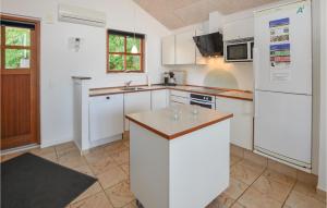 a kitchen with white cabinets and a white refrigerator at Marina Minde in Egernsund