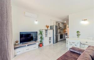 un salon avec une télévision et une cuisine dans l'établissement 1 Bedroom Cozy Apartment In Kneze, à Pupnat