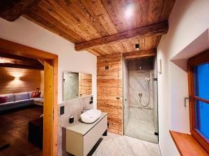 施文特Cosy Chalet with garden, fire pit & stunning views的带水槽和淋浴的浴室