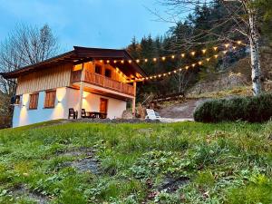 施文特Cosy Chalet with garden, fire pit & stunning views的山丘上一排灯的房屋
