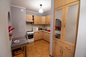 a kitchen with wooden cabinets and a white microwave at Zakątek Łąkowa in Suwałki
