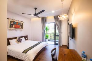 a bedroom with a bed and a table and a television at Casa Vanilla Mang Den in Kon Von Kla