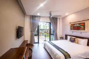 a bedroom with a bed and a desk and a window at Casa Vanilla Mang Den in Kon Von Kla