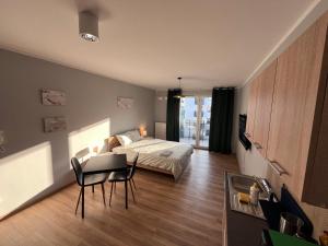 a bedroom with a bed and a table and a couch at Holdek Apartamenty Ceglana in Katowice