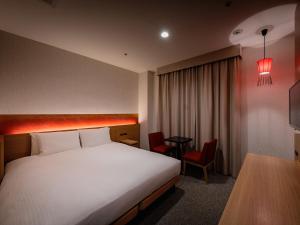 a hotel room with a bed and a table at Loisir Hotel Classic Garden Kyoto Sanjo in Kyoto