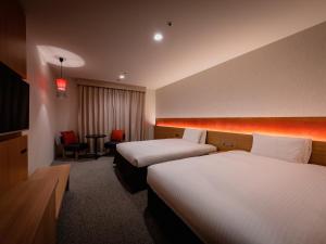 a hotel room with two beds and a chair at Loisir Hotel Classic Garden Kyoto Sanjo in Kyoto