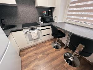 a kitchen with a counter and two chairs in it at Apartaments near Gabija in Mažeikiai +10 photos