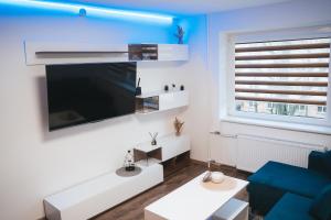 a living room with a large flat screen tv on a wall at Apartaments near Gabija in Mažeikiai