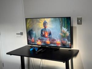 a flat screen tv sitting on a table with candles at Auckland City cozy Stay in Auckland