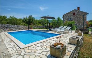 a pool in a yard with chairs and an umbrella at Holiday Home Burjaki Cr in Trgetari
