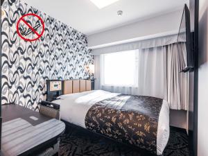 a hotel room with a bed and a no smoking sign at APA Hotel Shin Osaka Esaka Ekimae in Suita