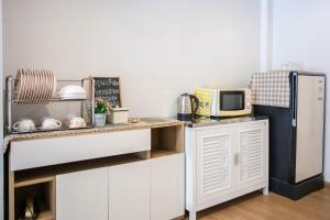 a kitchen with white cabinets and a refrigerator at Bangsean Smile Home บ้านสไมล์ บางแสน in Bangsaen